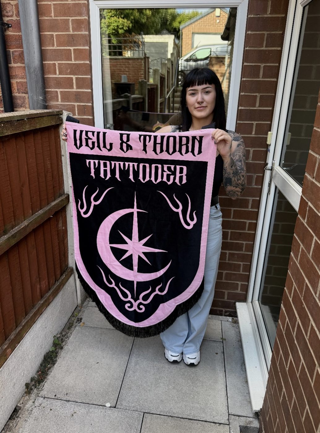 The Veil & Thorn banner held up in the studio doorway in Selby